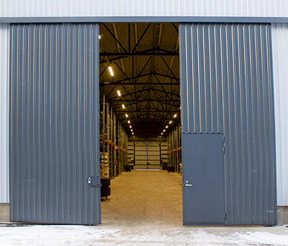 Industrial sliding door systems that optimize worker movement